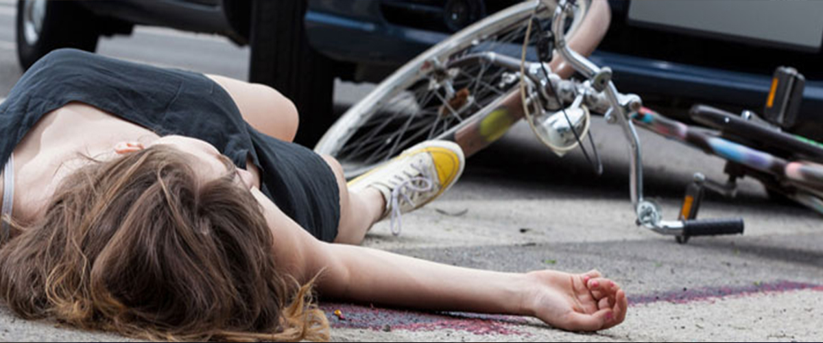A bleeding bicyclist on the roadway after an accident