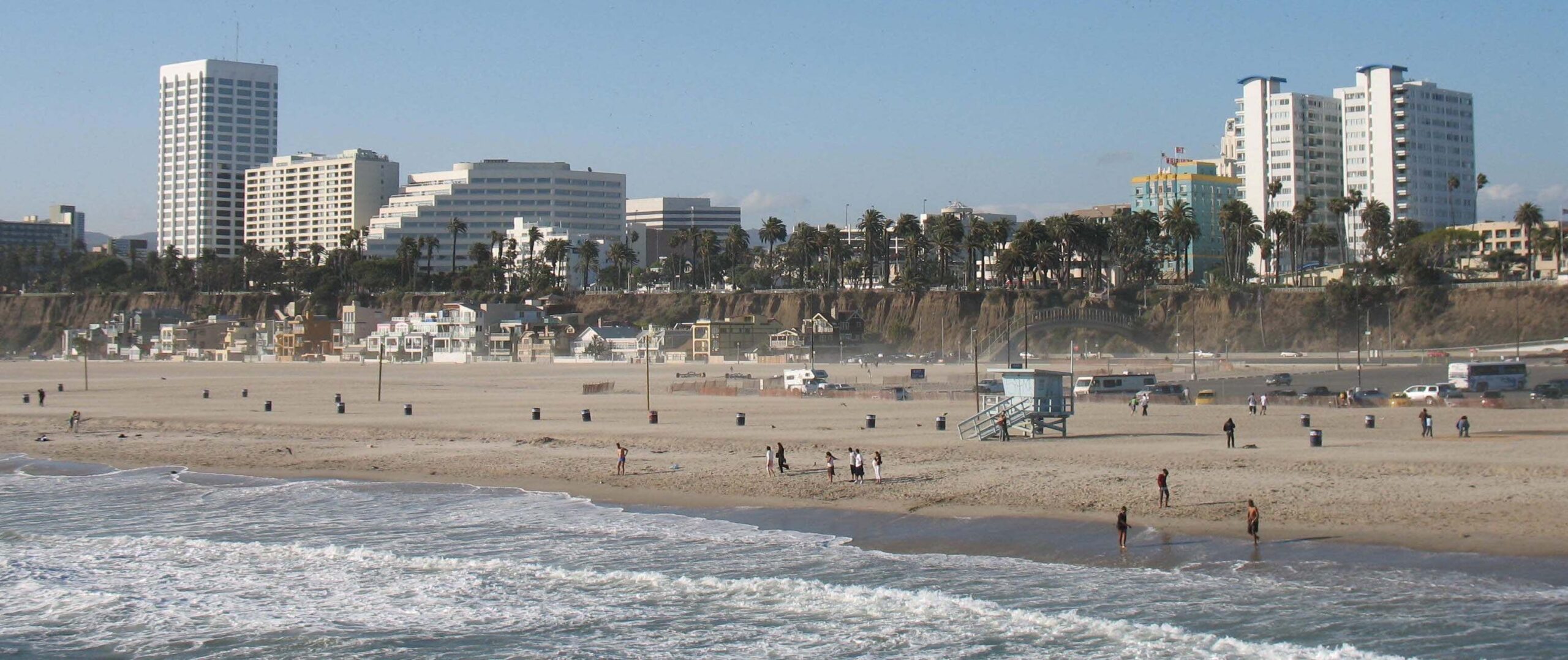 Santa Monica beach with a tall large office building housing Santa Monica Injury Attorneys in the skyline